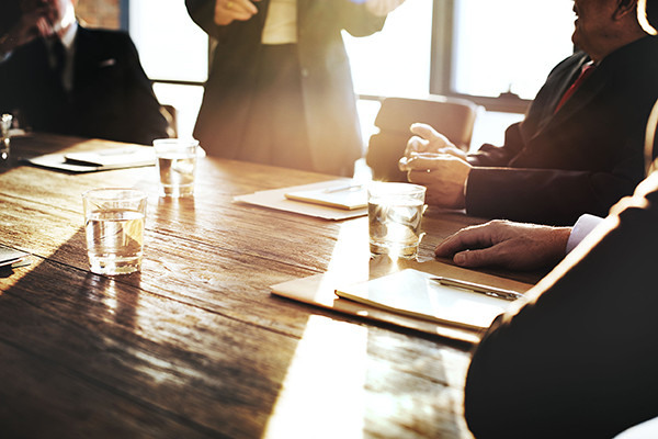 business meeting at a table with water and files on the table